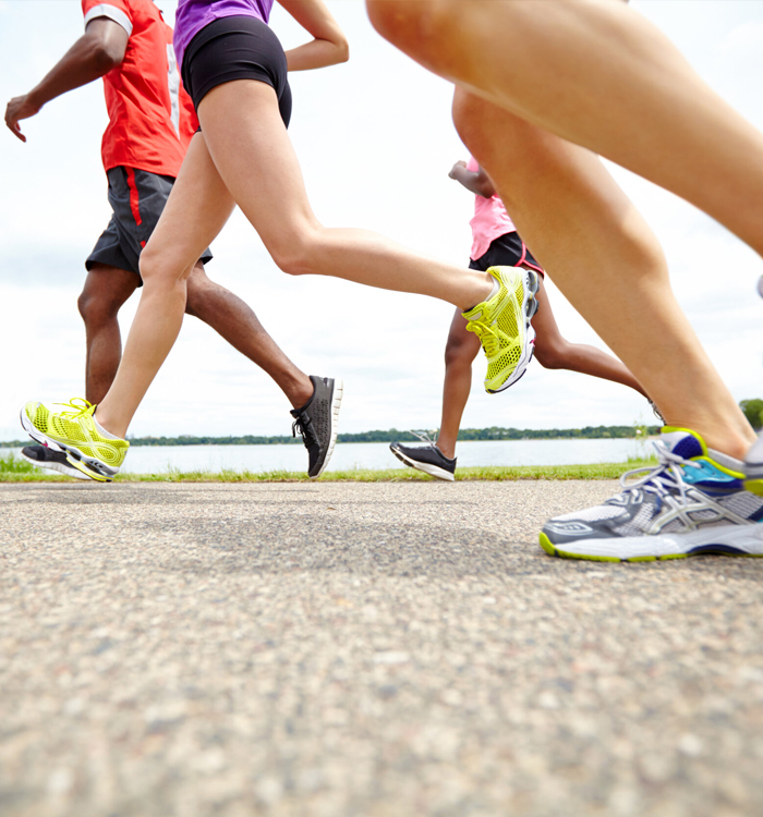 A team of people engaged in a group run on a road, highlighting the joy of exercise and social interaction.